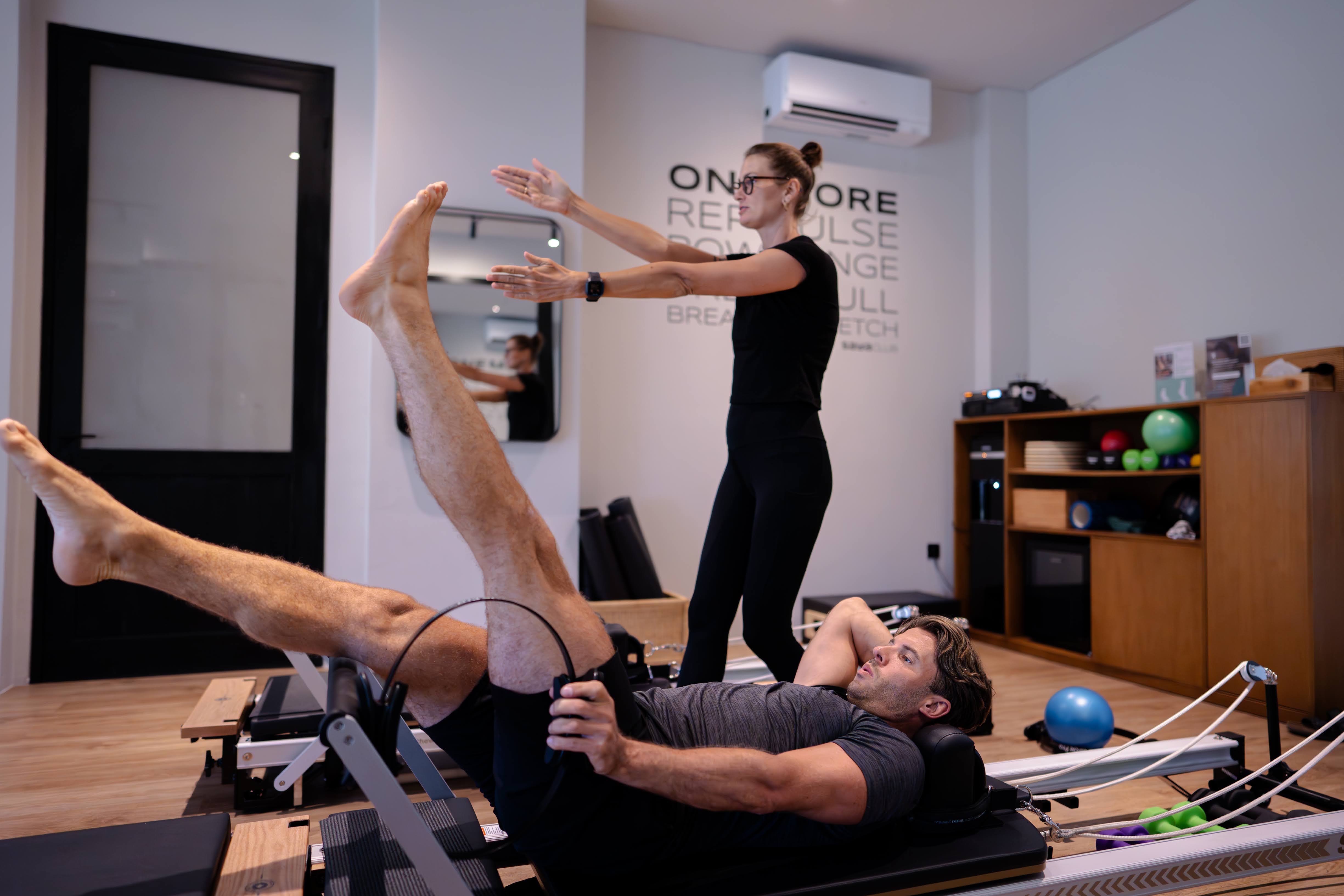 Male client on Reformer by wall